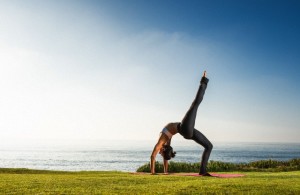 Women on cliff, in yoga position
